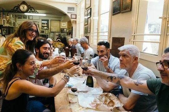 Gezelschap proost met Italiaanse wijn aan een tafel vol streekgerechten