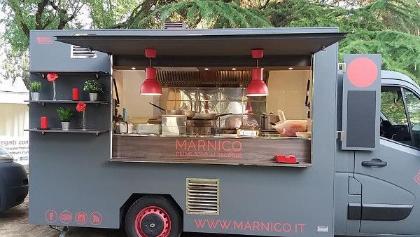 Een moderne grijze Italiaanse foodtruck genaamd Marnico met rood-zwarte details.