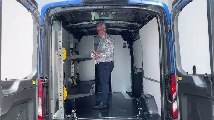 Man inspecteert het Work System reksysteem in een blauwe bestelwagen.
